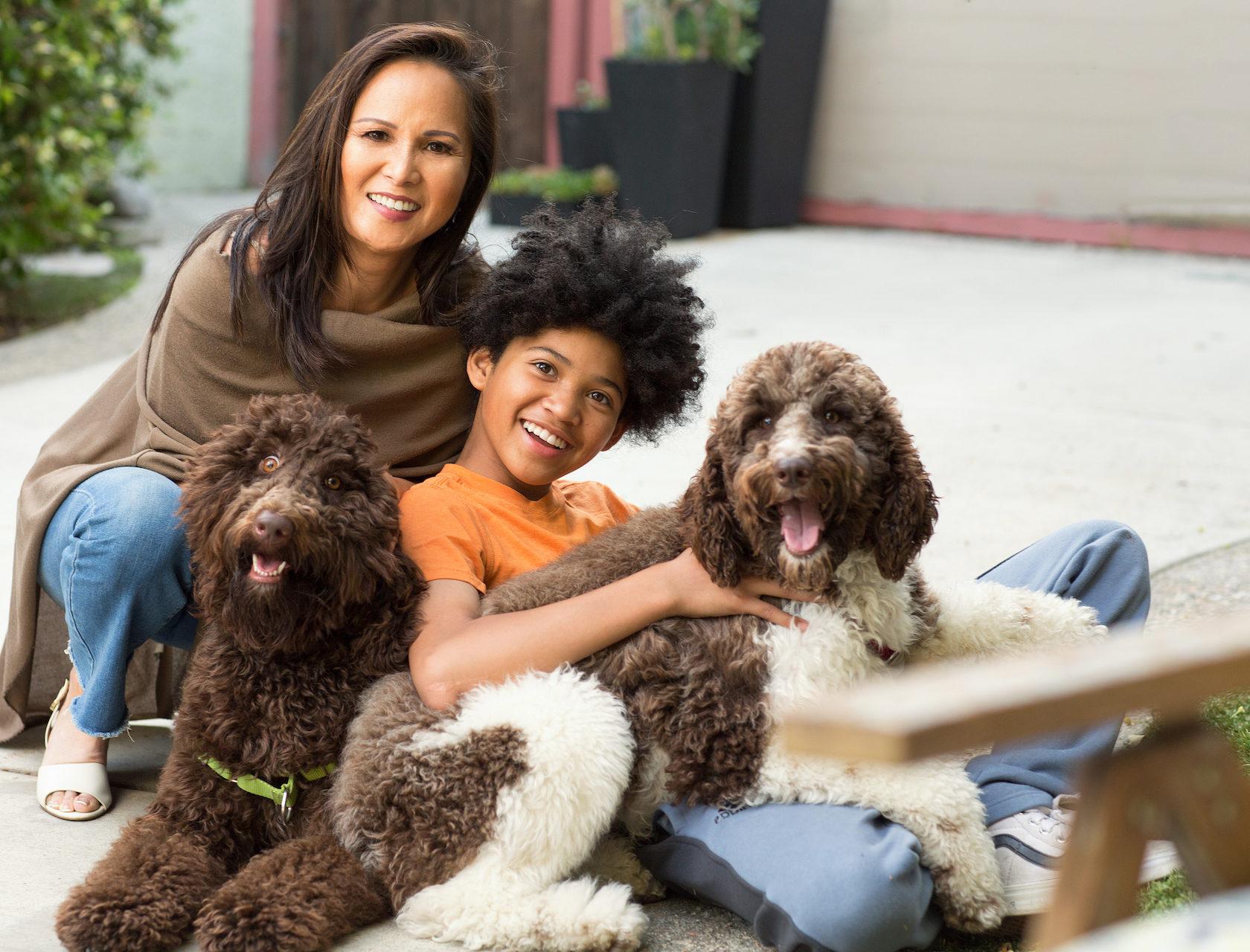 Happy mixed race family playing with their dog.