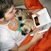 Photo of boy reading with 2 pugs