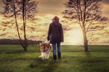 woman walking her dog into the horizon